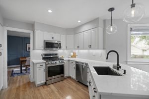 Updated kitchen with white cabinetry and stainless steel appliances at 8060 W 78th Circle